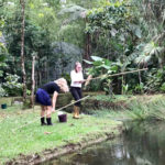 Volunteers help with fishing for enrichments at the Ecuador wildlife sanctuary